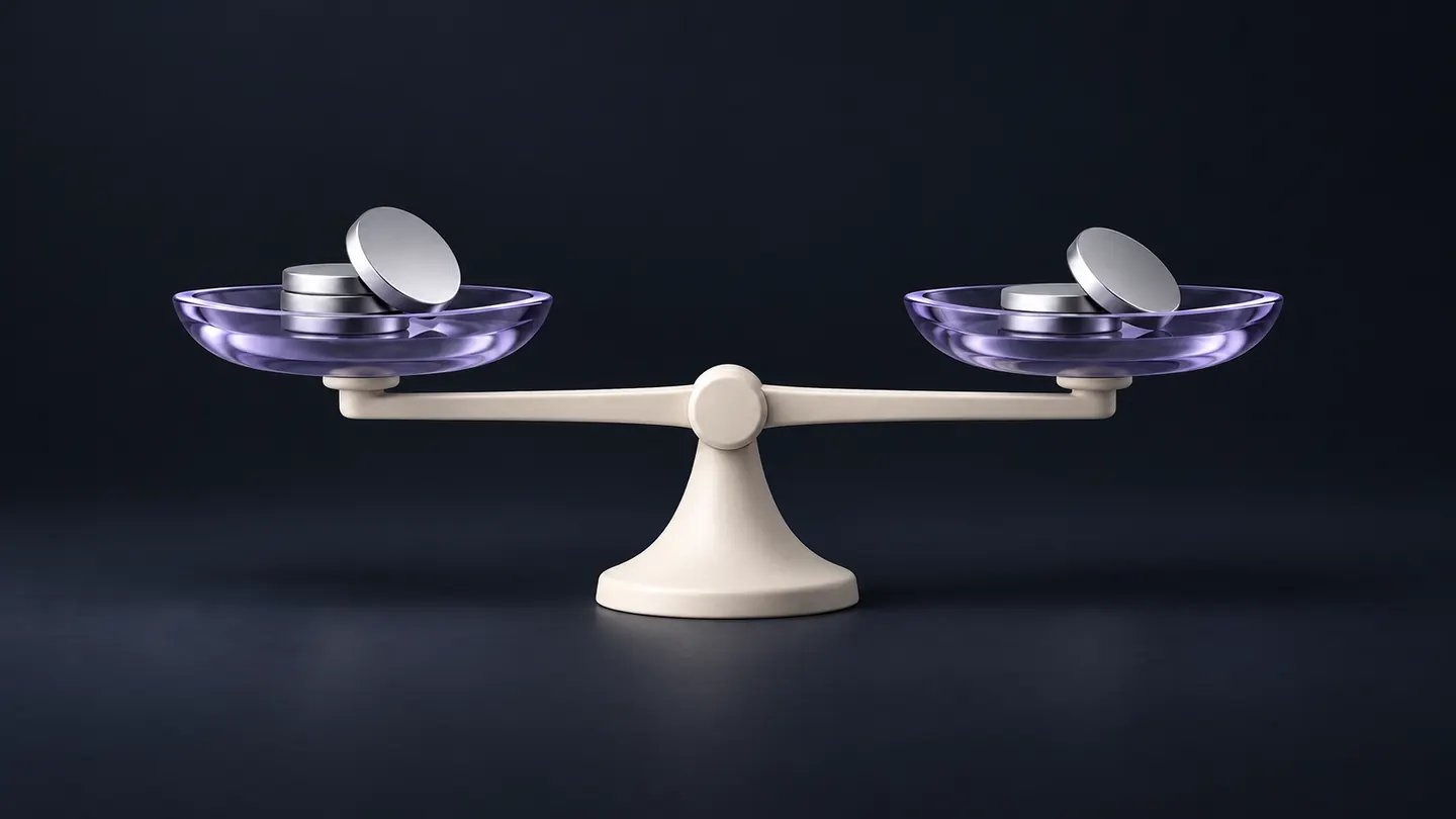 An ivory balance scale with lavender glass pans holding blank silver coins.