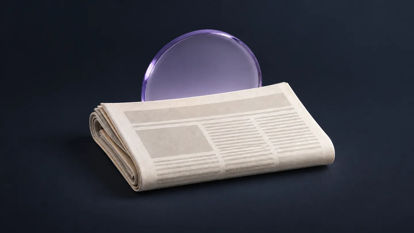 A folded ivory newspaper in front of a lavender glass sunrise disc.